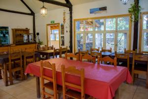 a dining room with a red table and chairs at Rukalhue in San Martín de los Andes