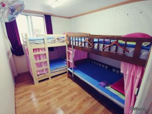 um quarto com 2 beliches e uma janela em Daejeon Guesthouse Sky Garden em Daejeon