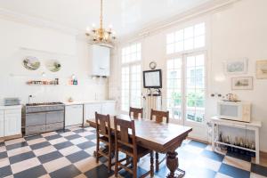 a kitchen with a table and chairs in a room at Veeve - Antique Charm by Arc de Triomphe in Paris