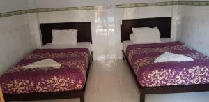 - deux lits assis l'un à côté de l'autre dans une pièce dans l'établissement Wahyu Homestay 2, à Nusa Lembongan