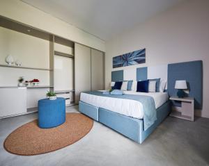 a bedroom with a large bed with blue accents at VOI Marsa Siclà Essentia in Sampieri