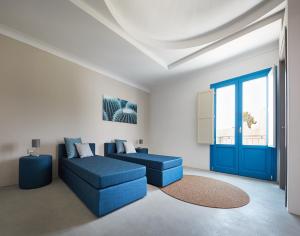 a living room with blue furniture and a blue door at VOI Marsa Siclà Essentia in Sampieri