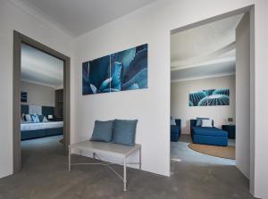 a living room with a blue chair and a bedroom at VOI Marsa Siclà Essentia in Sampieri
