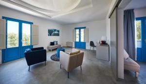 a living room with blue and white furniture and windows at VOI Marsa Siclà Essentia in Sampieri