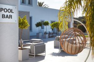 a patio with chairs and a sign for a pool bar at VOI Marsa Siclà Essentia in Sampieri