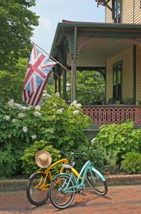 dos bicicletas estacionadas frente a una casa con bandera británica en The Queen Victoria en Cape May