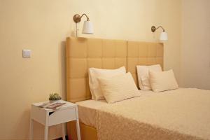 uma cama com duas almofadas e uma mesa lateral com um candeeiro em Alecrim Rosmaninho Guest House em Pinhel
