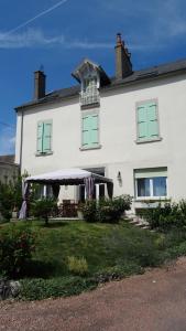 Casa blanca con ventanas verdes y porche en Chambres d'hotes Maison Gille, en Nuits-Saint-Georges