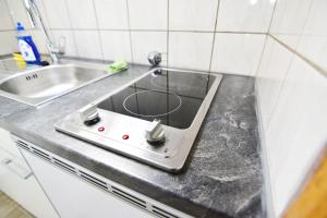 eine Küchentheke mit Herd und Spüle in der Unterkunft Apartment Köln Porz in Köln + 33 Fotos
