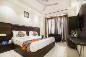 Habitación de hotel con cama y escritorio en FabExpress Le Continental en Nueva Delhi