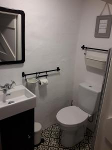 a bathroom with a white toilet and a sink at Cissy's Cottage - traditional thatched cottage, near to beach in Aghanloo +19 photos