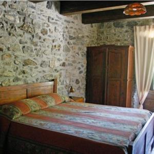 a bedroom with a bed and a stone wall at Hotel Ristorante Mulino Iannarelli in San Severino Lucano