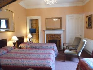 a hotel room with two beds and a desk at Averon Guest House in Edinburgh