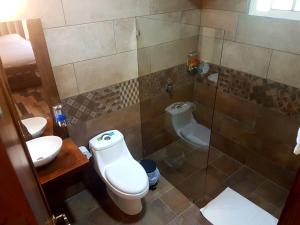 Un baño con inodoro, lavabo y ducha. en Casa El Granero Monteverde, en Monteverde