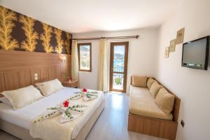 a bedroom with a bed and a couch and a tv at Hotel Pirat in Kalkan +22 photos