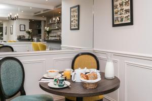 a table with breakfast food on it in a restaurant at Hotel Saint Christophe in Paris