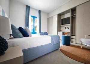 a bedroom with a large white bed with blue pillows at VOI Marsa Siclà Essentia in Sampieri