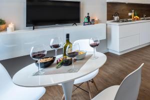 a white dining table with wine glasses and snacks at Z-ArchSuites in Rome