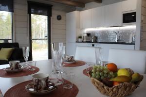 a kitchen with a table with a basket of fruit at Naava Chalet Lumi 301 in Ähtäri