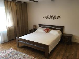 a bedroom with a bed with a wooden headboard at EcoLodge in Novoselitsa