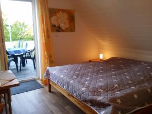 a bedroom with a bed and a balcony with a table at Dat Inselhuus in Norden