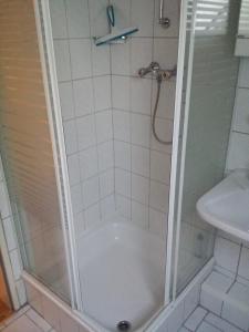 a shower with a glass door next to a sink at Dat Inselhuus in Norden +16 photos