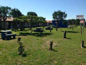een park met picknicktafels en bomen in het gras bij Garopaba Praia Club in Camacho