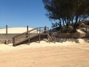 een houten trap in het zand in de woestijn bij Garopaba Praia Club in Camacho
