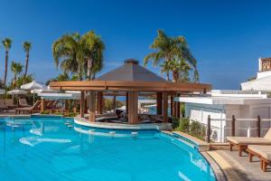 a swimming pool with a gazebo next to a building at Mediterranean Beach Hotel in Limassol