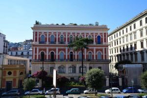 duży różowy budynek z balkonem w mieście w obiekcie 50 SUITE Relais&Relax w mieście Napoli