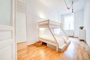 - une chambre avec un lit et du parquet dans l'établissement Vachova Apartments, à Brno