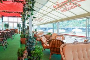 a dining room with tables and chairs and a bridge at Botel Albatros in Prague