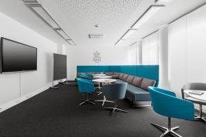 a conference room with a couch and a table and chairs at Serways Hotel Siegburg West in Siegburg