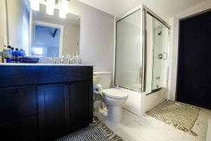 a bathroom with a toilet and a glass shower at Hillside Colorado Cottages in Hillside +67 photos