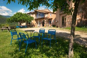 um grupo de cadeiras e uma mesa em frente a uma casa em Casa Rural Mas Garganta em La Pinya