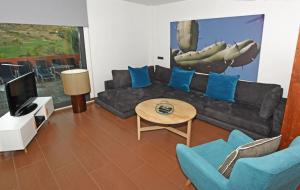 uma sala de estar com um sofá e uma televisão em Salobre Las Tabaibas 1 em Maspalomas