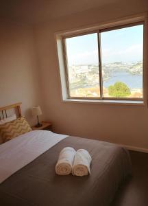 ヴィラ・ノヴァ・デ・ガイアにあるApartamento "La peinture de Porto"のベッドルーム1室(ベッド1台、大きな窓付)
