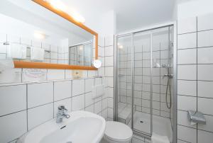 a bathroom with a sink and a toilet and a mirror at Locals Stadthotel Bielefeld in Bielefeld +69 photos