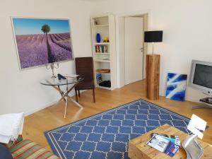 Business Apartment Ravensburg - sonnig, zentral & ruhig في رافنسبرغ: غرفة معيشة مع طاولة وتلفزيون