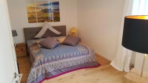 a bedroom with a bed and a painting on the wall at Business Apartment Ravensburg - sonnig, zentral & ruhig in Ravensburg