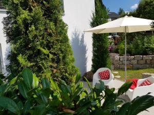 a patio with two chairs and an umbrella at Business Apartment Ravensburg - sonnig, zentral & ruhig in Ravensburg