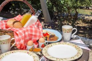 una mesa de picnic con platos de comida y una cesta de comida en Mainades Maisonettes & Studios, en Ménites