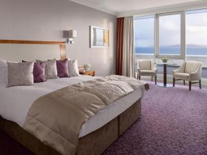
a hotel room with a bed, table, chairs and a window at Salthill Hotel in Galway
