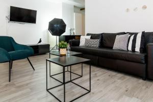 salon z kanapą i stołem w obiekcie JOIVY Exclusive Apt for 4 in Navigli near parks w Mediolanie