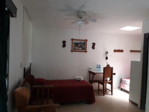 a bedroom with a red bed and a table at La Casa de Don David in El Remate