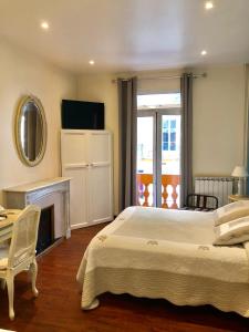 a bedroom with a bed and a fireplace and a mirror at Hotel Lepante in Nice