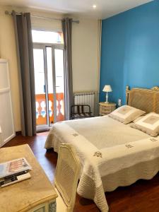 sypialnia z dużym łóżkiem z niebieską ścianą w obiekcie Hotel Lepante w Nicei