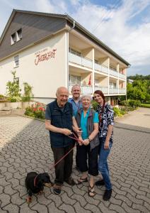 
a man and a woman standing next to a dog at Hotel Garni Jägerhof in Sigmaringen
