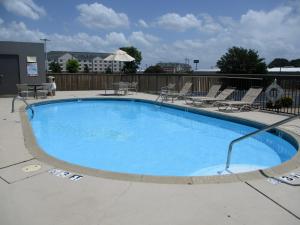 uma grande piscina com cadeiras ao redor em Motel 6-Conway, AR em Conway