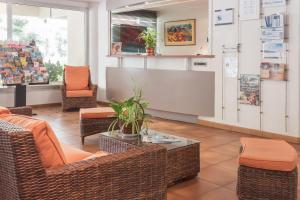 - une salle d'attente avec des chaises en osier et une table dans l'établissement Résidence Pierre & Vacances La Promenade des Bains, à Saint-Raphaël